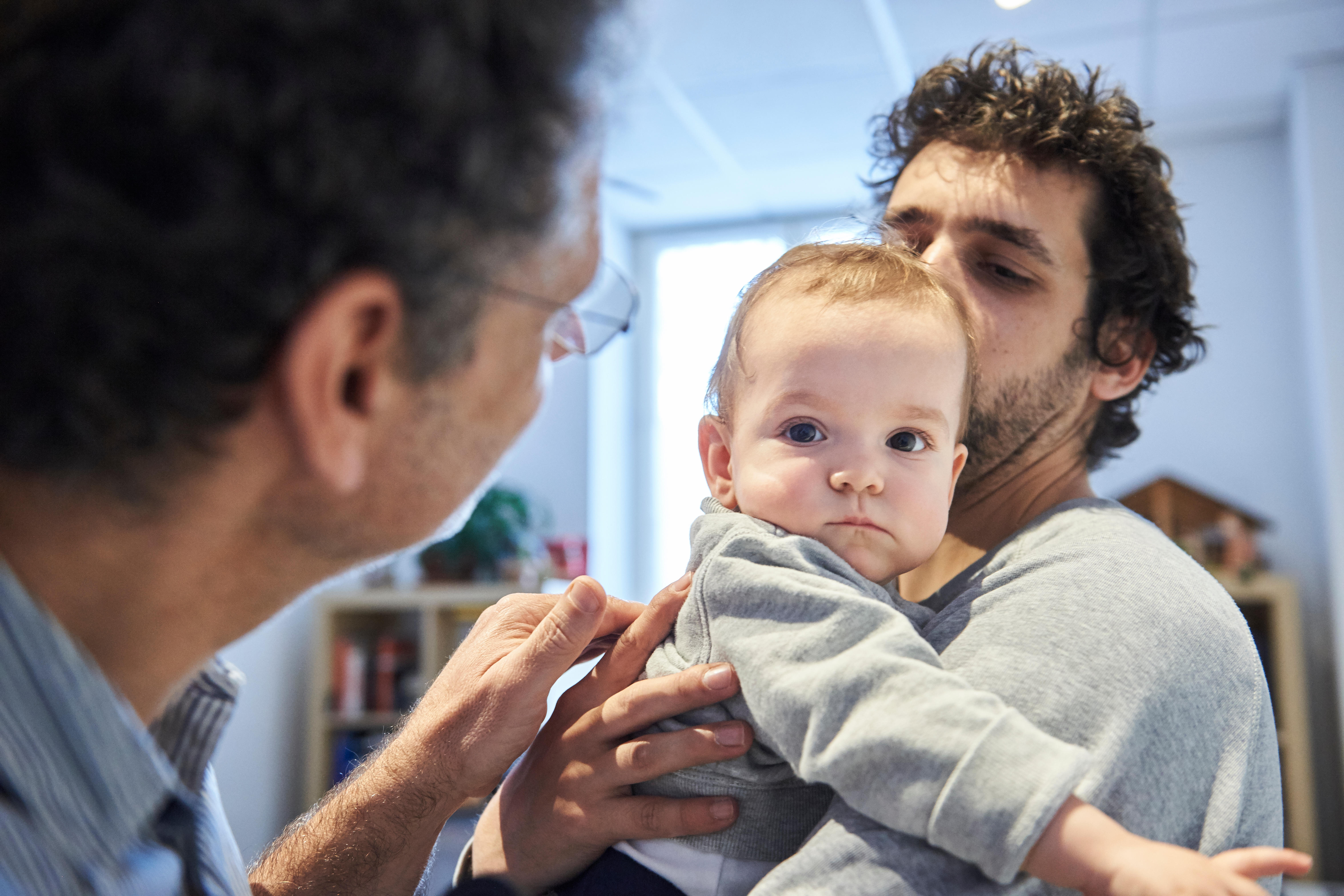 a dad and his baby visiting a medical professional